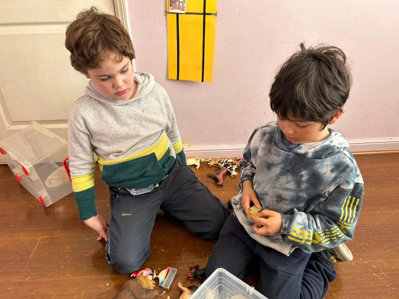 Dos niños en juego funcional con figuras de animales