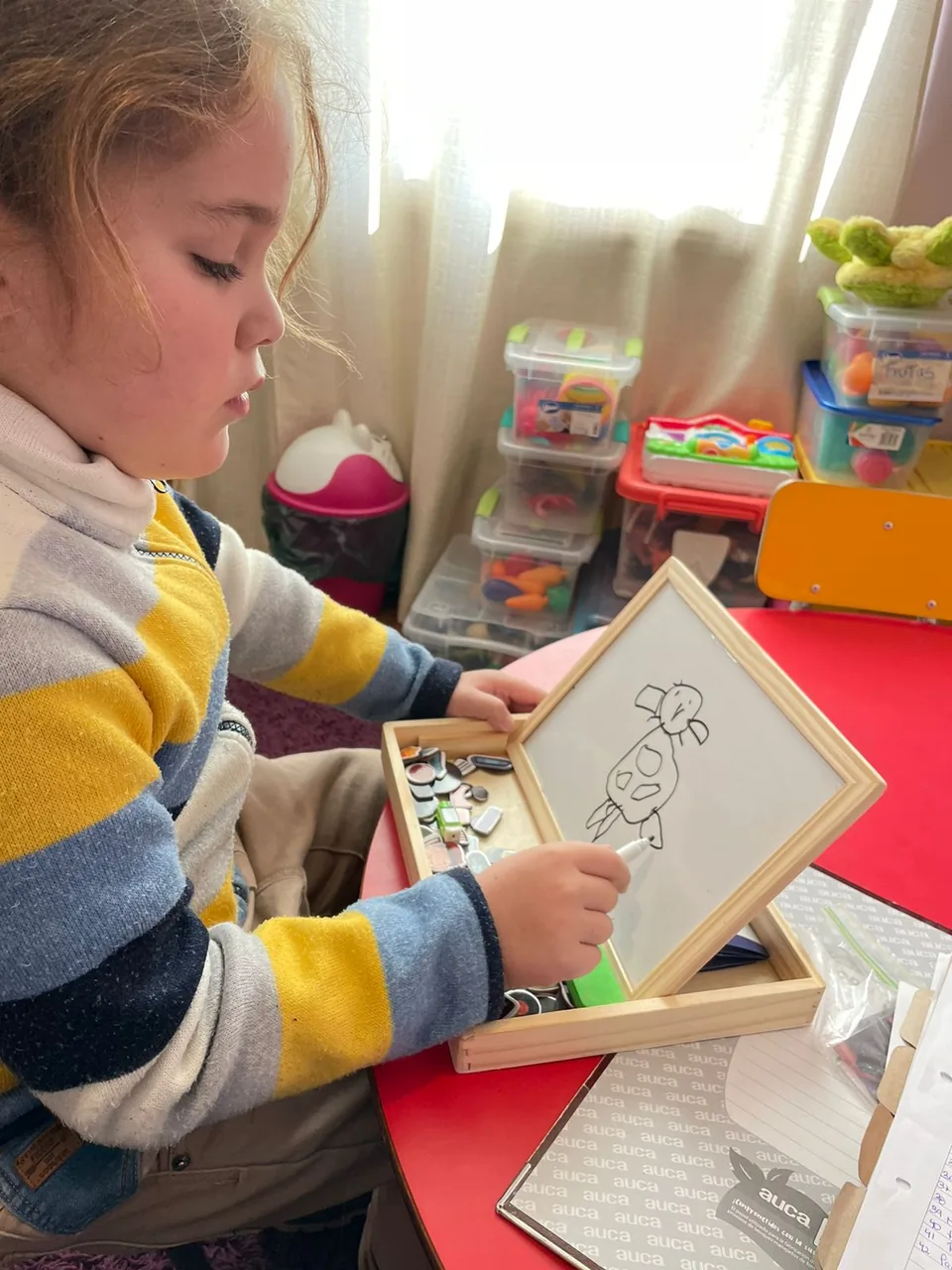 Niña trabajando con material de dibujo en sesión individual